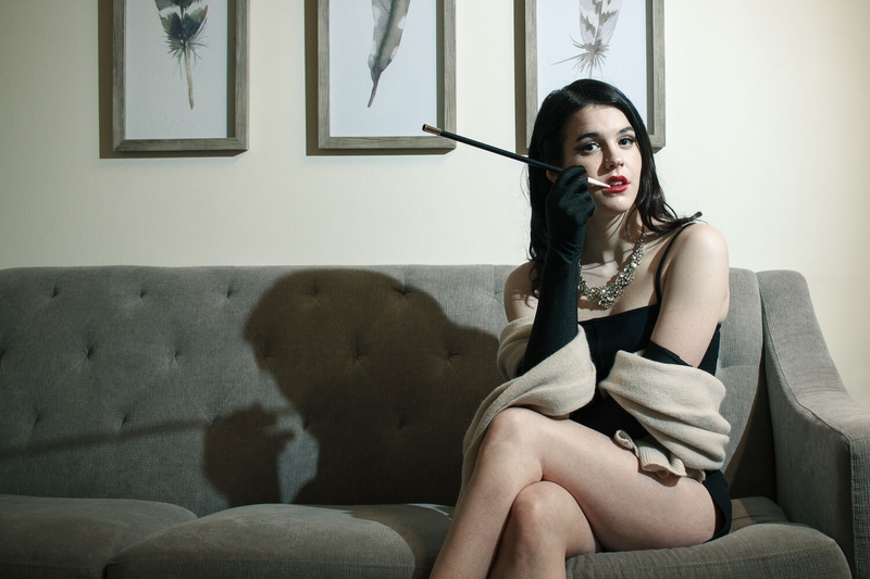 Portrait of a model sitting on a couch with old hollywood lighting style