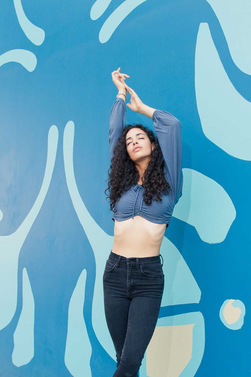 Model in front of a blue mural in SE Portland, OR