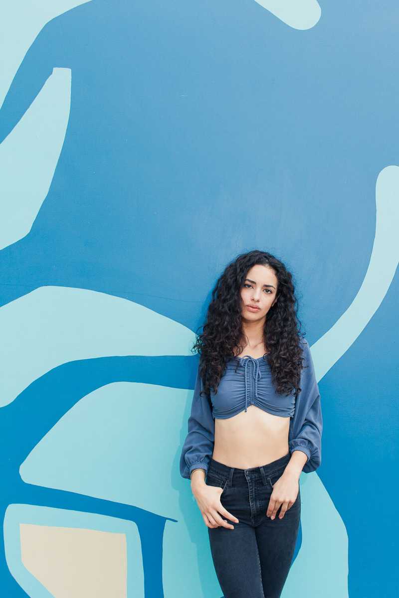 Model in front of a blue mural in SE Portland, OR